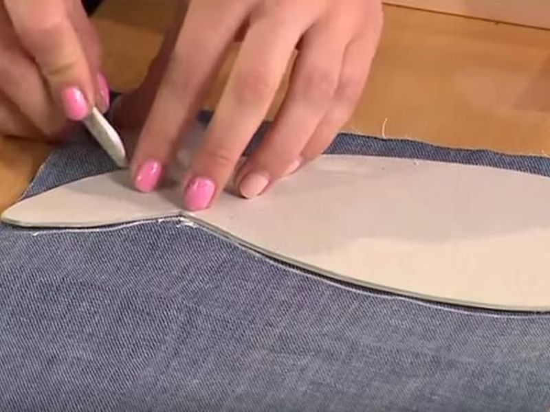 Ложим выкройку на джинсовую ткань, и обводим ее с помощью мела по контуру